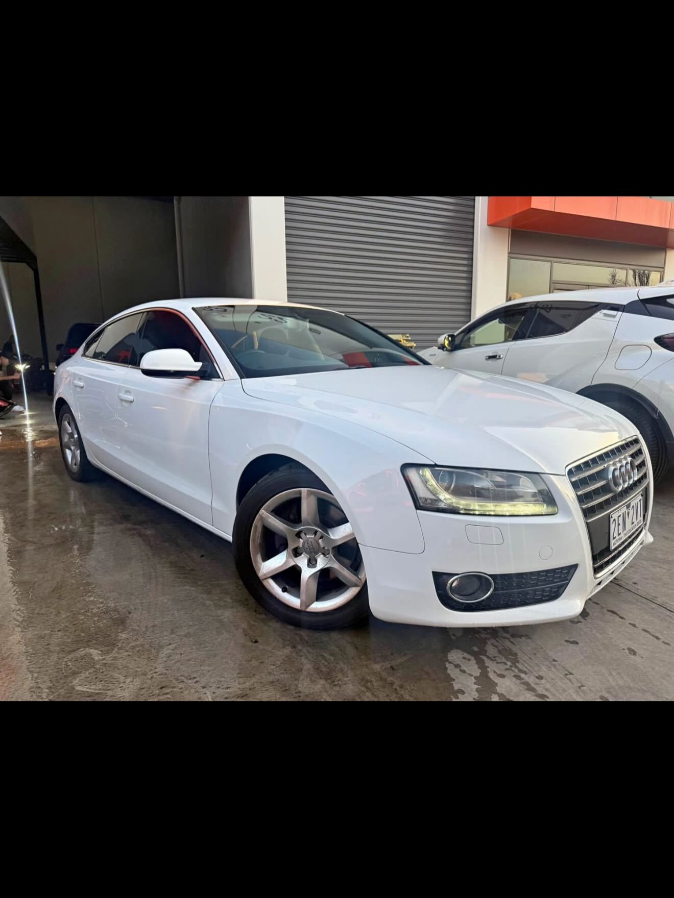Front three-quarter view of a white Audi A5 Sportback.