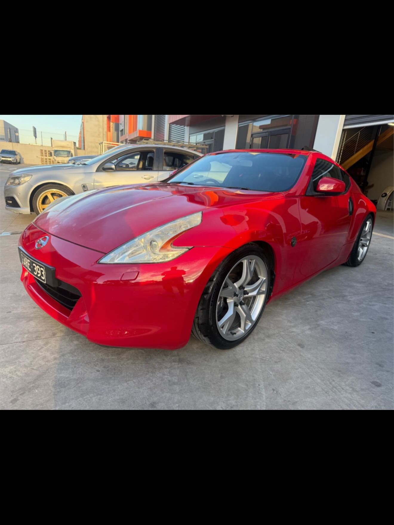 Front three-quarter view of a red Nissan 370Z coupe.