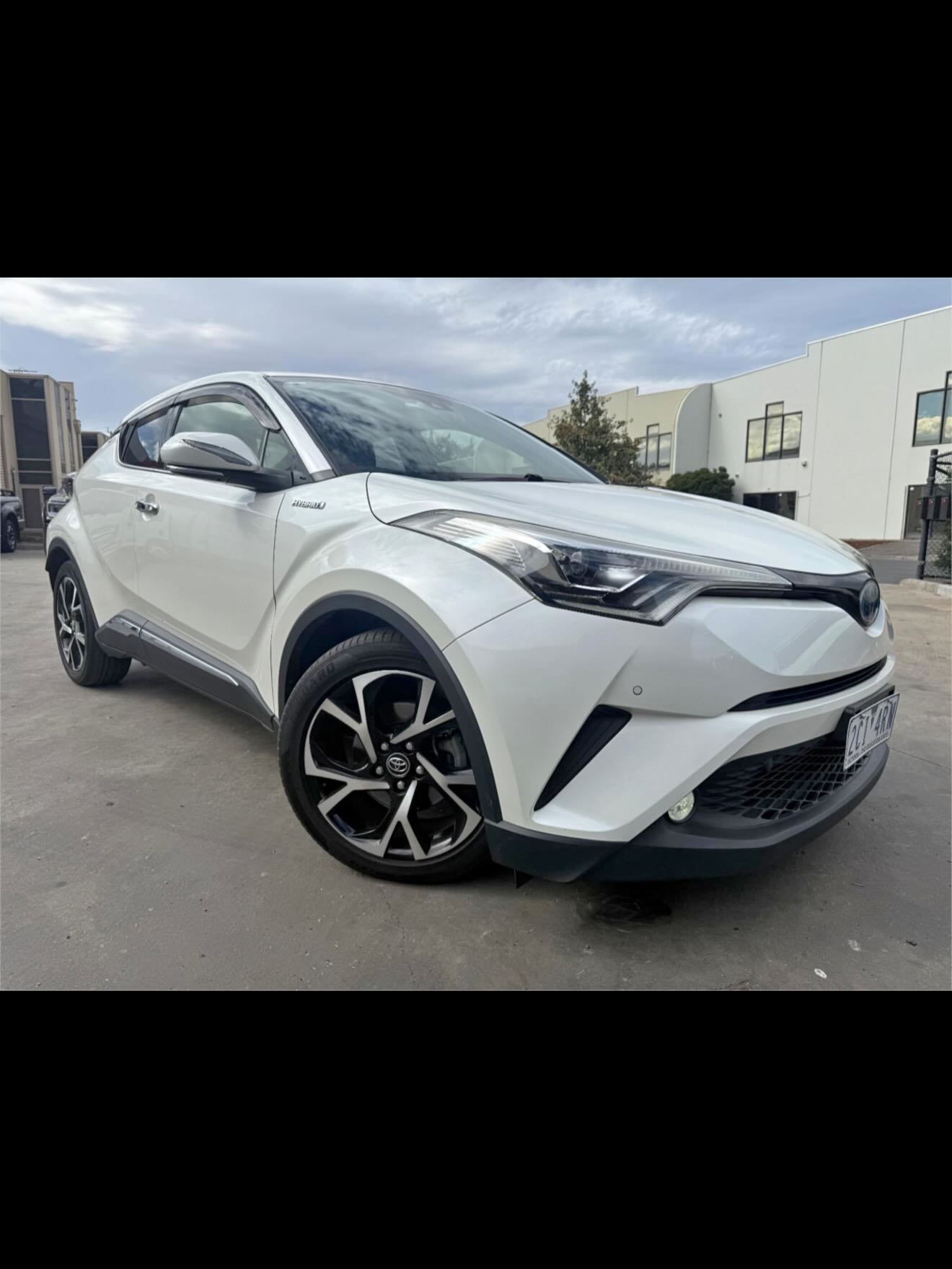 Front three-quarter view of a white Toyota C-HR hybrid.