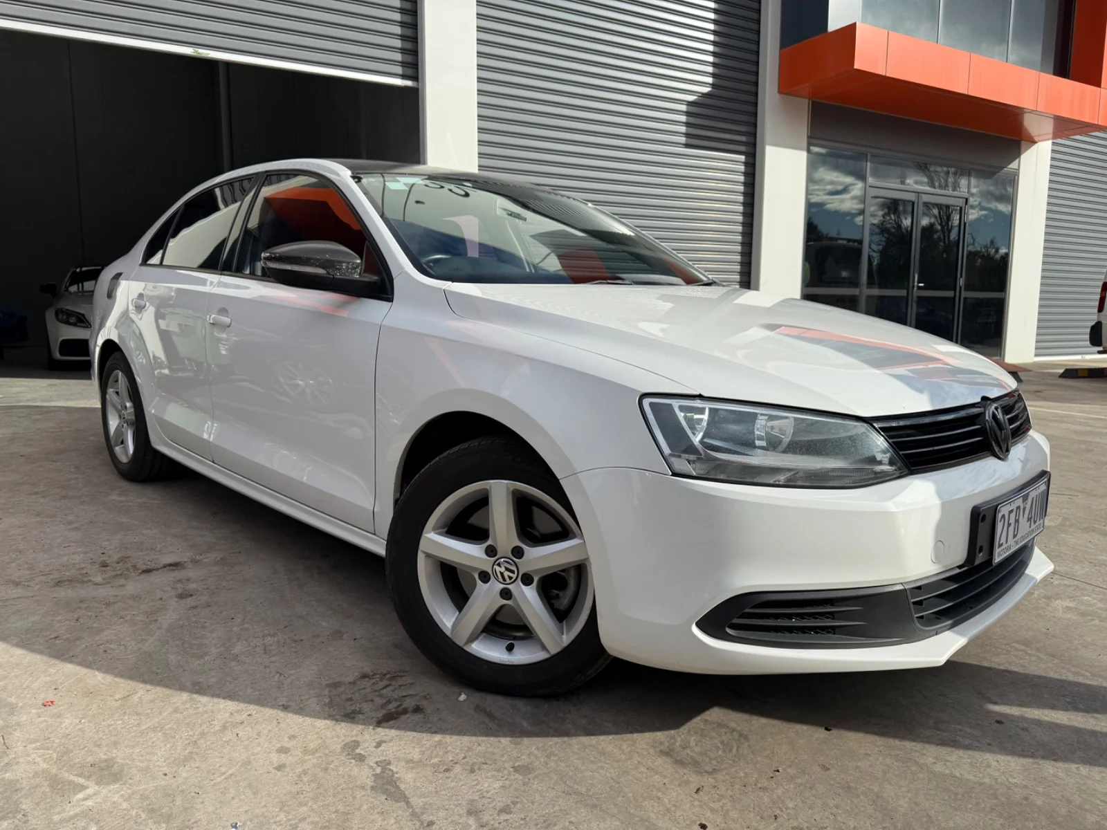 Front three-quarter view of a white 2014 Volkswagen Jetta 118 TSI sedan.