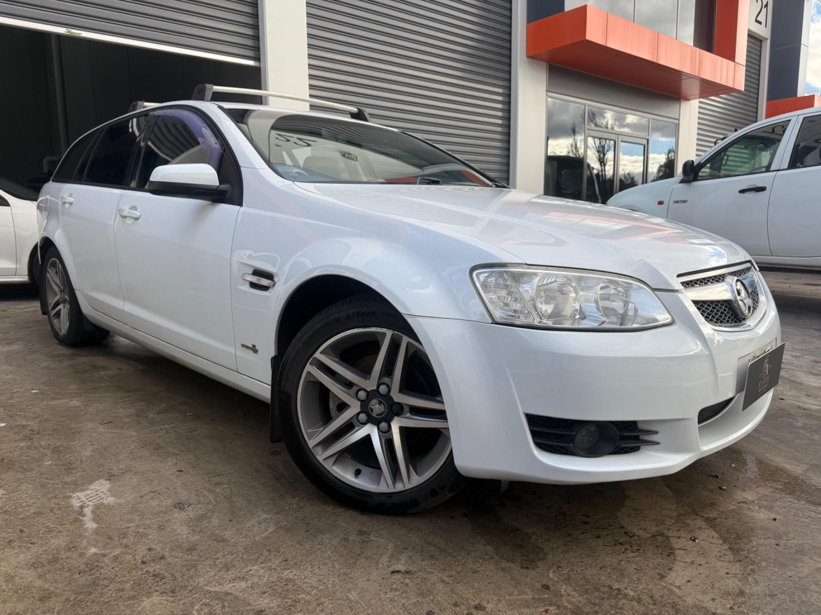 Front three-quarter view of a white 2010 Holden Commodore Berlina sportwagon.
